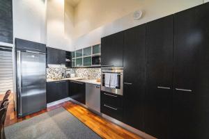 塔库沃里Vietti Suites的厨房配有黑色橱柜和不锈钢用具