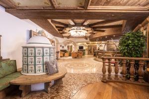 坎皮泰洛迪法萨Hotel Soreghes Gran Chalet的大型客厅设有木制天花板和桌子