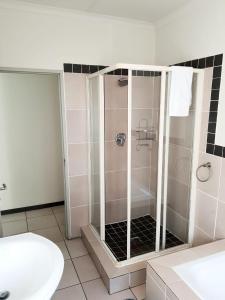 内尔斯普雷特NST City Apartments @ 9 Joubert的浴室里设有玻璃门淋浴