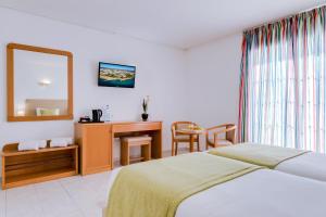 阿尔布费拉伊莎贝尔莫妮卡海滩俱乐部酒店的一间卧室配有一张床、一张书桌和一面镜子
