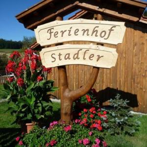 KollnburgFerienbauernhof Mehlbach的围栏前花园内鲜花的标志