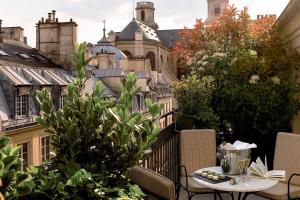 巴黎圣日尔曼埃斯普利特酒店的阳台配有桌椅和建筑