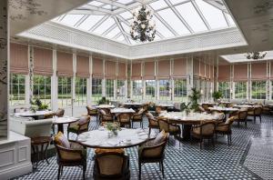 奥赫特拉德格伦伊格尔斯酒店的用餐室设有桌椅和窗户。
