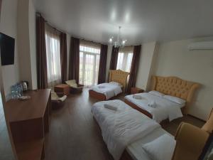 巴统Hotel Maria的酒店客房配有两张床和一张书桌