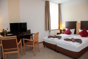 Strasen祖木罗温旅馆的酒店客房设有两张床、一张桌子和一台电视。