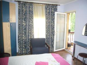 锡纳亚Complex Vile Daniel的卧室配有床、椅子和窗户。