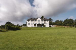 肯德尔Lyth Valley Country House的绿色田野顶部的白色大房子