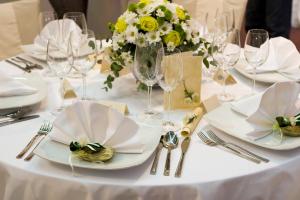 锡尔克堡达尼亚酒店的白桌,带盘子和玻璃杯,花瓶