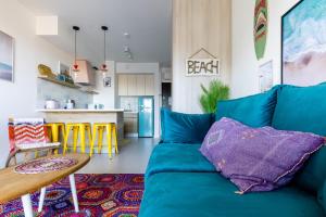 格但斯克Apartamenty Your Seaside的一间带蓝色沙发的客厅和一间厨房