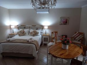 博福特西Quaggasfontein Gastehuis的一间卧室配有一张床和一张木桌