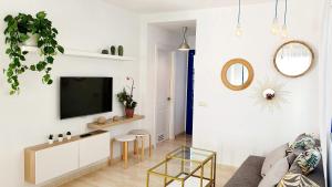 普拉亚布兰卡Casa azul的一间客厅,在白色的墙上配有电视