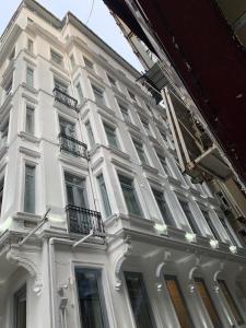 伊斯坦布尔Taksim Galatist Hotel的白色的建筑,窗户在建筑的一侧