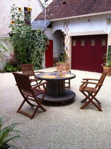 诺让莱罗特鲁Chambre-studio Le 42的一个带桌子和两把椅子的庭院和一个车库