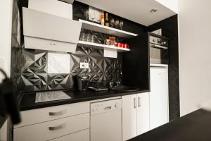诺维萨德Chill Out Apartment的厨房配有白色橱柜和黑色墙壁