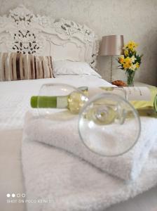 廷塔杰尔科里士满酒店的一张带毛巾的白色床和一杯葡萄酒