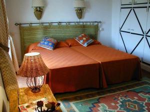 曼查雷亚尔卡萨拉卡特塔乡村酒店的一间卧室配有一张床和一张带台灯的桌子