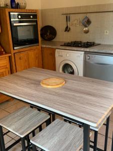 菲加里Gîte à Poggiale de Figari的厨房配有木桌和两把椅子