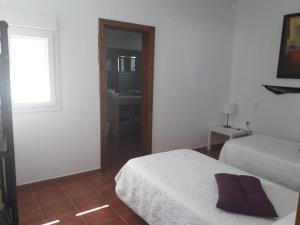 GüimeHOTEL RURAL FINCA LA CALERA lanzarote的一间白色卧室,配有两张床和窗户