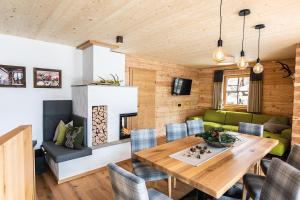 瓦格赖恩Bergseegut Chalet und Apartment的一间带木桌和绿色沙发的用餐室
