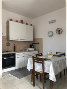 布罗达里卡Apartmani Nevena的厨房配有白色橱柜和桌椅