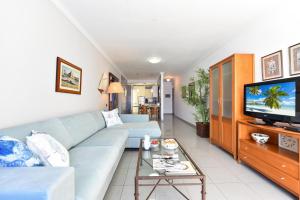 莫甘海滩Luxury BeachFront Mogan的客厅配有蓝色的沙发和电视