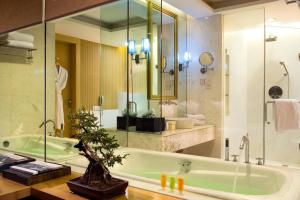 苏州苏州温德姆花园的浴室配有绿色浴缸和水槽