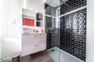 布里夫拉盖亚尔德POMPIDOU #2 - Chic & Elégant - 1 chambre的浴室铺有黑色地铁瓷砖,设有玻璃淋浴间。