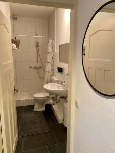 弗伦斯堡Zentrumsnahe schöne Altbauwohnung bis 4 Personen的一间带水槽、卫生间和镜子的浴室