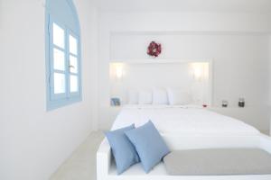 阿克罗蒂里维拉玛利亚客房酒店的白色卧室配有白色床和蓝色枕头