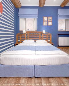 敖德萨Lucky Ship Art Hotel的一间卧室配有一张带蓝色墙壁的大床