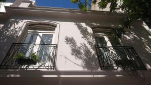 布宜诺斯艾利斯534 Petit San Telmo - Studio & Suites的白色的房子,设有窗户和阳台
