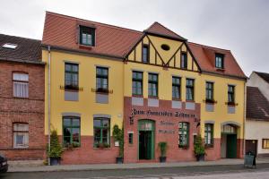 沃利茨Gasthaus und Pension "Zum Hauenden Schwein"的街道上的黄色建筑