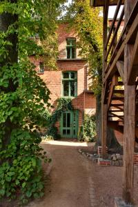 沃利茨Gasthaus und Pension "Zum Hauenden Schwein"的前面有一扇绿门的砖房