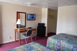 TerryvillePLYMOUTH MOTOR LODGE的酒店客房设有两张床和一张带电脑的书桌