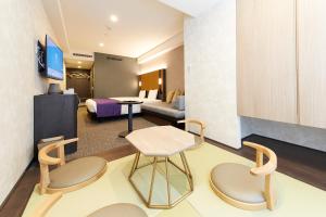 京都hotel MONday KYOTO MARUTAMACHI的酒店客房带一张床、一张桌子和椅子