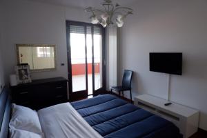 蒙特西尔瓦诺Appartamento Residence Acquarius的一间卧室配有一张床、一张书桌和一台电视