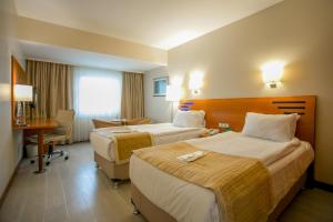 伊斯坦布尔伊斯坦布尔市假日酒店的酒店客房配有两张床和一张书桌