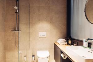 施泰尔harry's home hotel & apartments的带淋浴、卫生间和盥洗盆的浴室