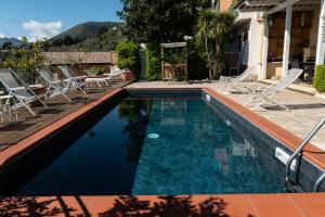 蒙雷亚莱BnB Casa Rossa的一个带椅子的游泳池以及一座房子