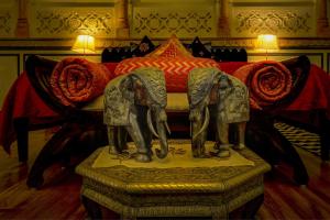 斋浦尔The Umaid Vilas Royal Heritage Haveli的一张床上的两头大象雕像