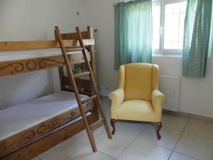 曼德琉-拉纳普勒Maisonnette au calme et proche mer的一间卧室配有双层床和黄色椅子
