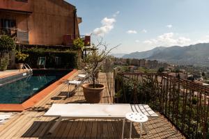 蒙雷亚莱BnB Casa Rossa的阳台设有游泳池、桌子和椅子。