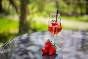 巴特梅根特海姆达斯恰夫梅沃夫酒店的桌子上放着一杯葡萄酒和草莓