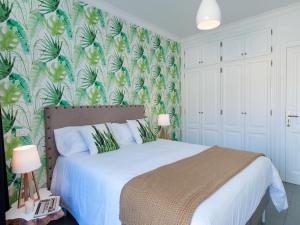 莫甘海滩Amazónico Playa de Mogán的一间卧室配有一张带热带壁纸的床