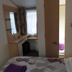 奥赫特拉德Deer lodge的一间卧室配有一张床、一张书桌和一个窗户。