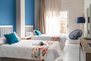 圣安东尼奥·德·卡隆Hotel Aubí的蓝色墙壁客房的两张床