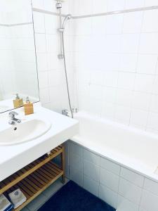 里昂Chez Marie的白色的浴室设有水槽和浴缸。