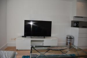 伦敦Northside Apartments Ealing的一间客厅,在白色的架子上配有电视