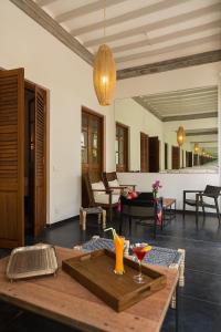 蓬蒂切里维拉酒店的客厅配有桌子,并提供饮料