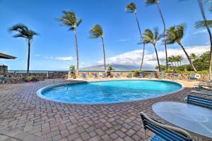基黑Ocean-View Kihei Condo with Lanai Steps to Beach!的一个带棕榈树和桌椅的游泳池